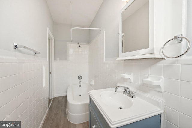 bathroom with vanity,  shower combination, tile walls, and hardwood / wood-style flooring