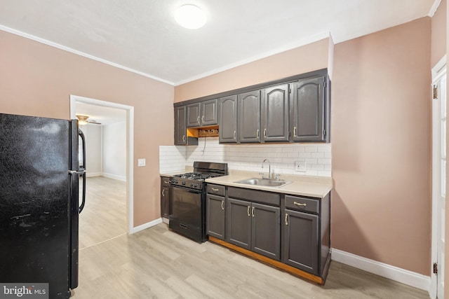 kitchen with black appliances, light hardwood / wood-style floors, gray cabinetry, sink, and backsplash