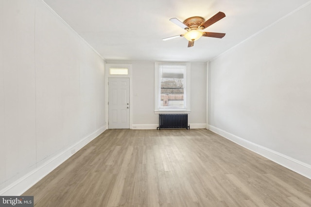 unfurnished living room with light wood-type flooring, ceiling fan, radiator, and ornamental molding