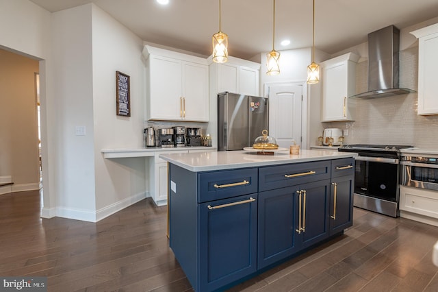 kitchen with decorative light fixtures, blue cabinets, white cabinetry, stainless steel appliances, and wall chimney exhaust hood