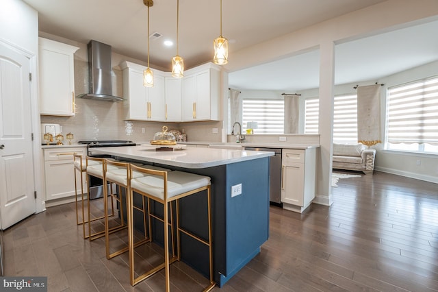 kitchen featuring white cabinetry, wall chimney exhaust hood, and appliances with stainless steel finishes