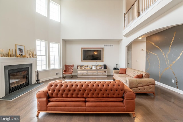 living room featuring wood-type flooring and a high ceiling