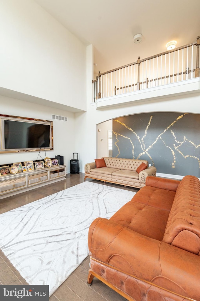 living room with a towering ceiling and hardwood / wood-style floors