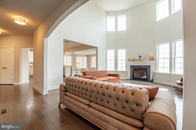 living room with dark hardwood / wood-style floors and a high ceiling