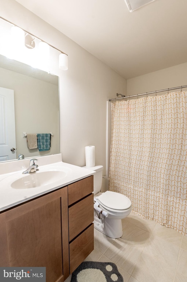 bathroom with vanity, curtained shower, tile patterned floors, and toilet