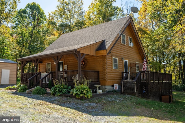 log home featuring log exterior, a porch, a shingled roof, and stairs