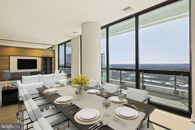 unfurnished dining area featuring expansive windows, a water view, and light hardwood / wood-style flooring