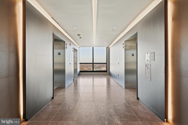 hallway featuring a wall of windows and elevator