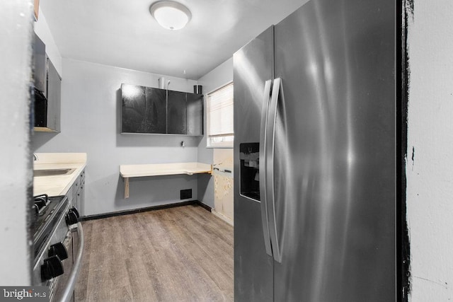 kitchen with sink, hardwood / wood-style floors, and stainless steel appliances