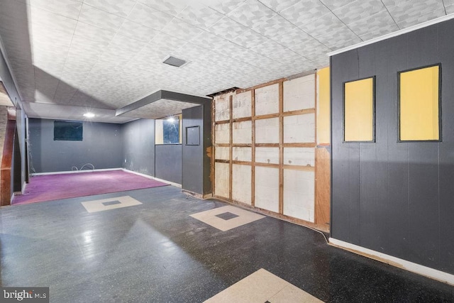 basement featuring wood walls