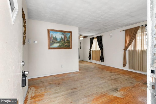 spare room with ceiling fan, light hardwood / wood-style floors, and a textured ceiling