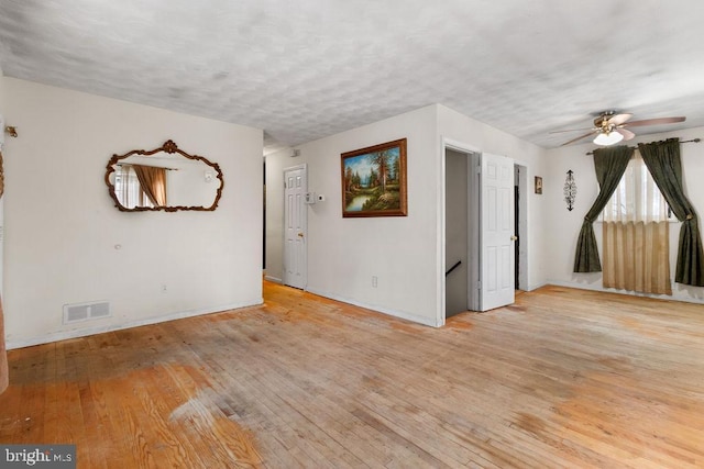 spare room with ceiling fan, a textured ceiling, and light wood-type flooring