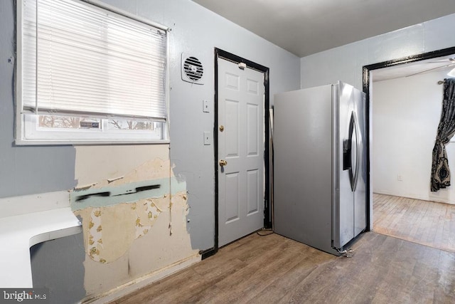 kitchen with wood-type flooring and stainless steel refrigerator with ice dispenser