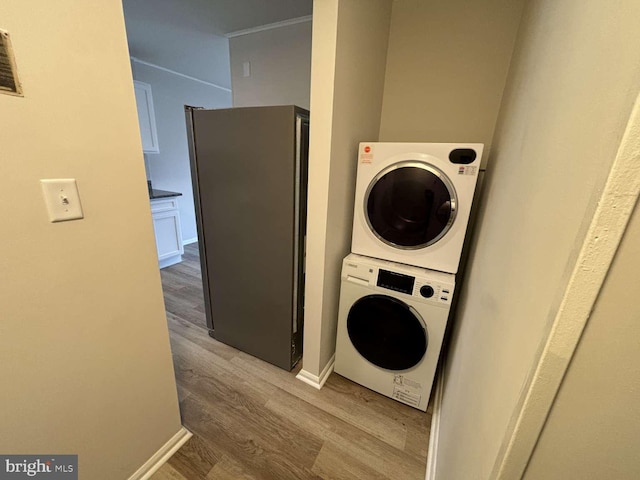 washroom featuring stacked washer / dryer and hardwood / wood-style flooring