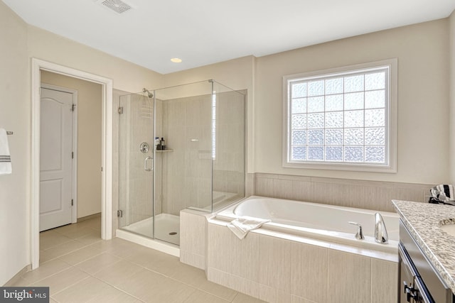 bathroom featuring tile patterned flooring, vanity, and plus walk in shower