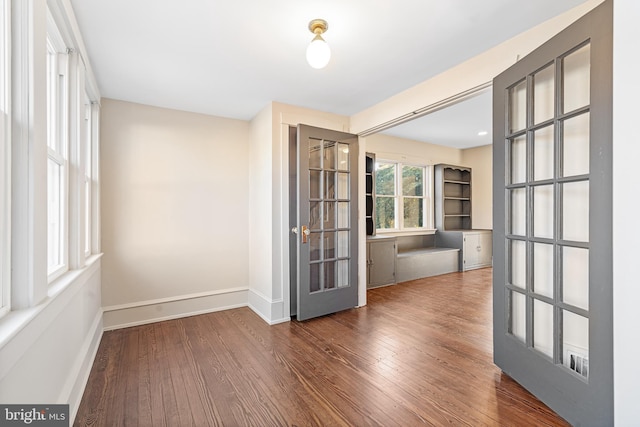 unfurnished room with dark hardwood / wood-style floors and french doors