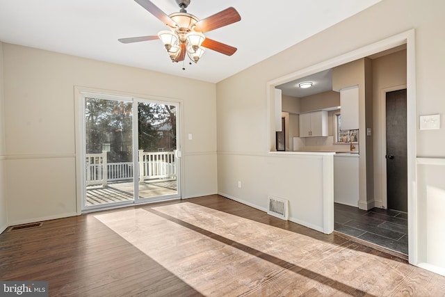 spare room featuring ceiling fan and dark wood-type flooring