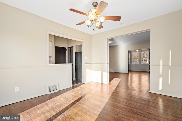 empty room featuring ceiling fan and dark wood-type flooring