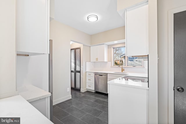 kitchen featuring white cabinets, decorative backsplash, stainless steel dishwasher, and sink