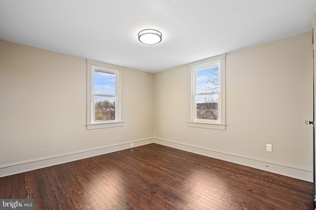 unfurnished room with a healthy amount of sunlight and dark hardwood / wood-style floors