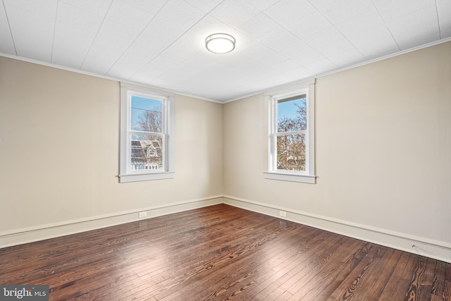 spare room with a healthy amount of sunlight, crown molding, and wood-type flooring