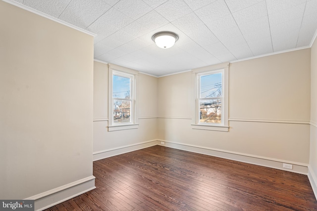 spare room featuring ornamental molding, a wealth of natural light, and hardwood / wood-style floors