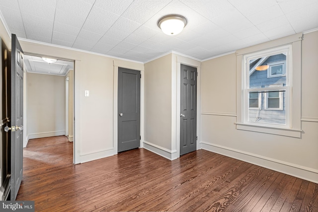 unfurnished bedroom with dark hardwood / wood-style floors and ornamental molding