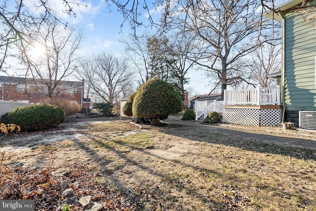 view of yard with a deck and central AC