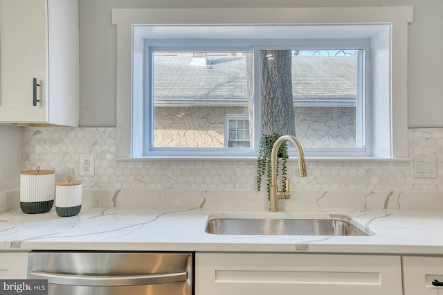 kitchen with sink, backsplash, white cabinets, and dishwasher