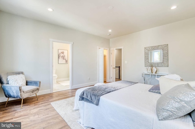 bedroom with light wood-type flooring and ensuite bath