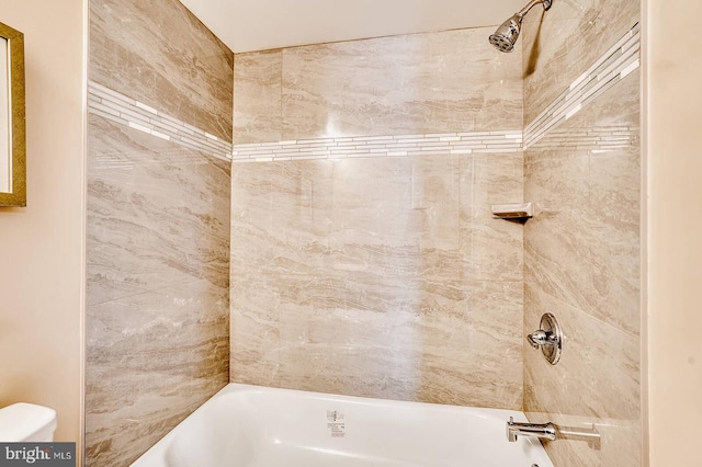 bathroom with tiled shower / bath and toilet