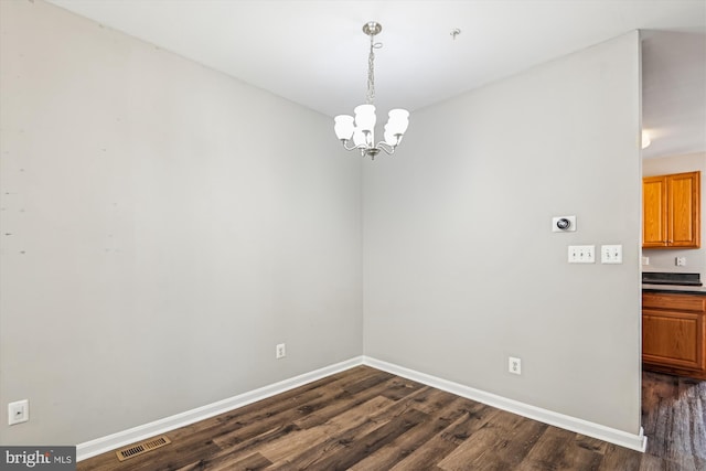 unfurnished dining area featuring dark hardwood / wood-style flooring and a notable chandelier