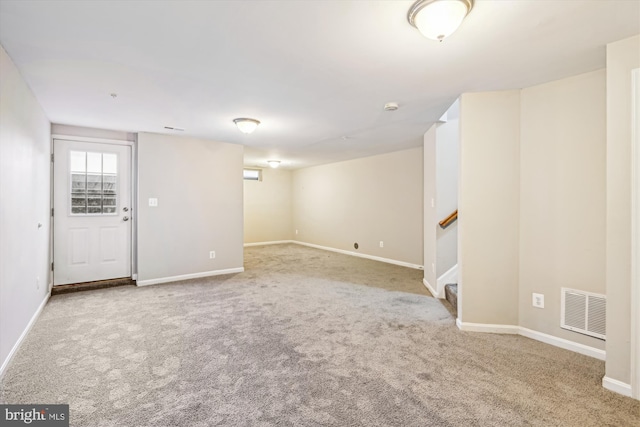 basement featuring light carpet