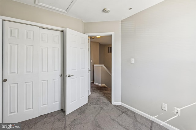 unfurnished bedroom with a closet and light carpet