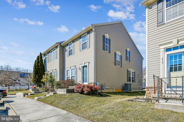 view of side of home featuring central AC unit and a lawn