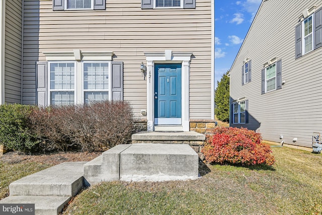 entrance to property featuring a lawn