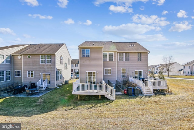 back of house featuring a wooden deck and a lawn