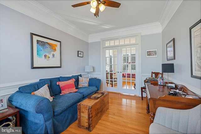 living room featuring crown molding, light hardwood / wood-style flooring, ceiling fan, and french doors