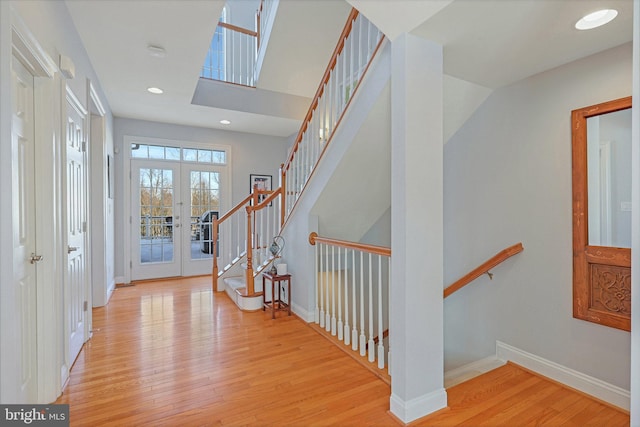 entryway with french doors and light hardwood / wood-style flooring