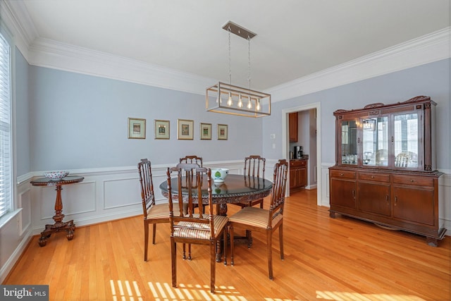 dining room with crown molding and light hardwood / wood-style floors