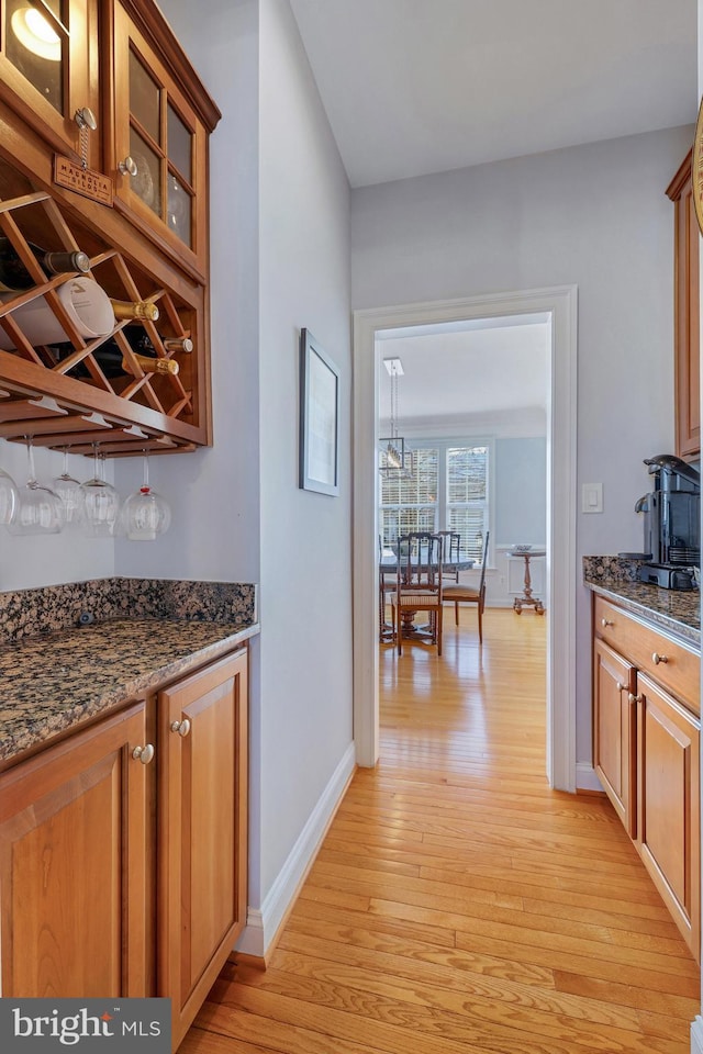 interior space with light wood-type flooring and dark stone counters