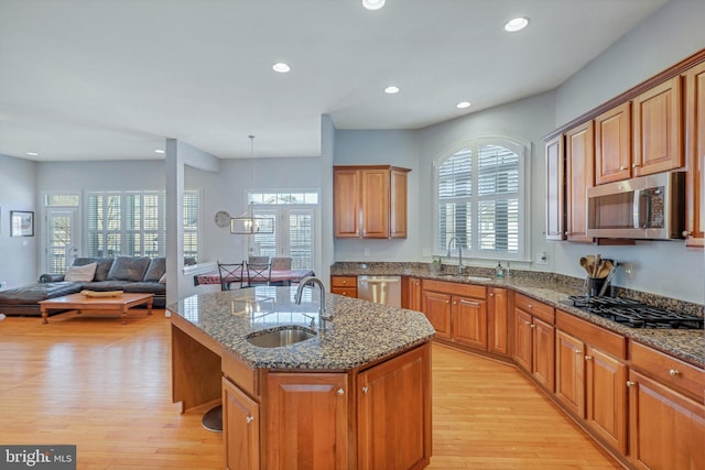 kitchen featuring appliances with stainless steel finishes, sink, a center island with sink, and light hardwood / wood-style floors