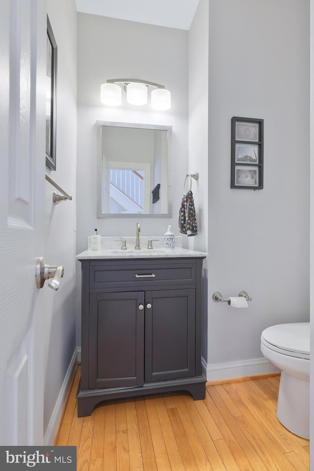 bathroom featuring vanity, hardwood / wood-style flooring, and toilet