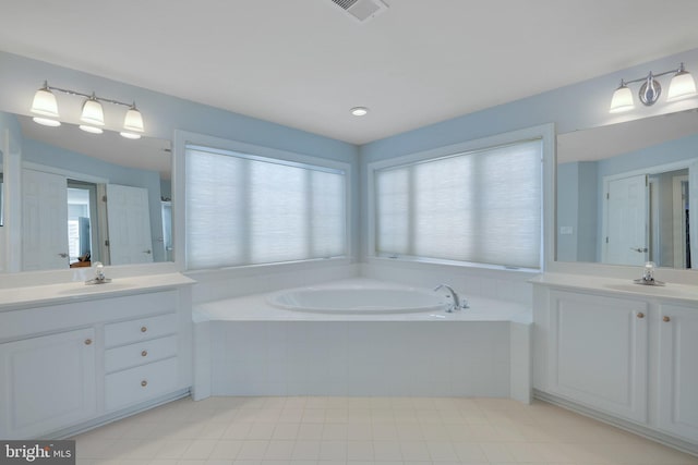 bathroom with vanity, tile patterned flooring, and tiled bath