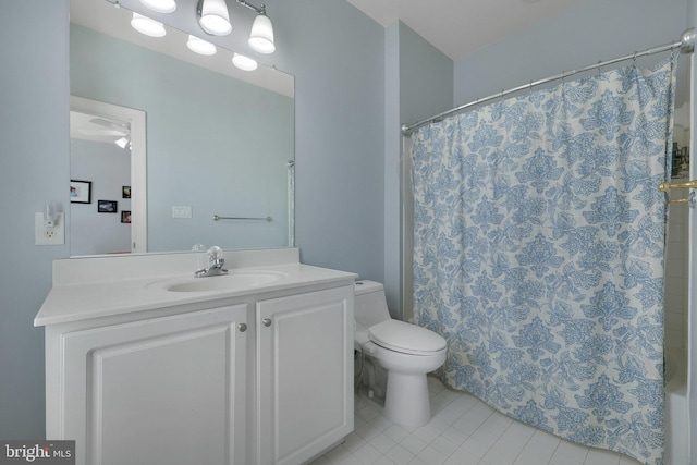 bathroom featuring walk in shower, vanity, toilet, and tile patterned flooring