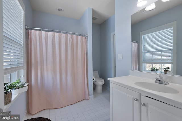 bathroom featuring vanity, tile patterned floors, toilet, and walk in shower