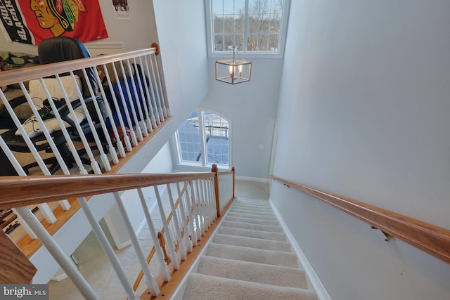 stairs with carpet flooring and a high ceiling