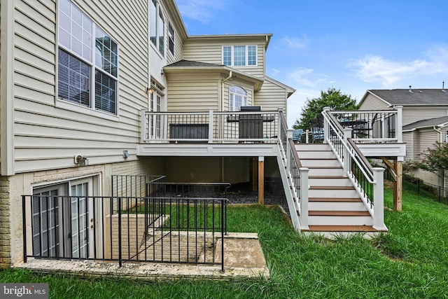 rear view of property with a wooden deck and a yard