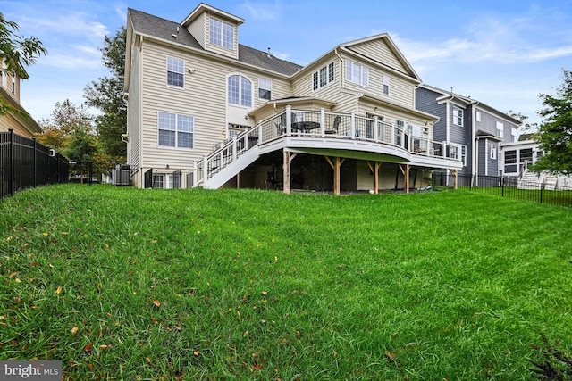 rear view of property with a wooden deck and a lawn