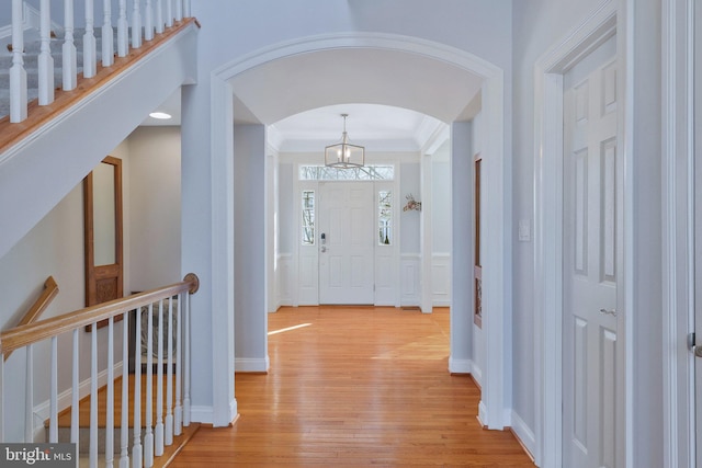 entryway featuring crown molding and light wood-type flooring